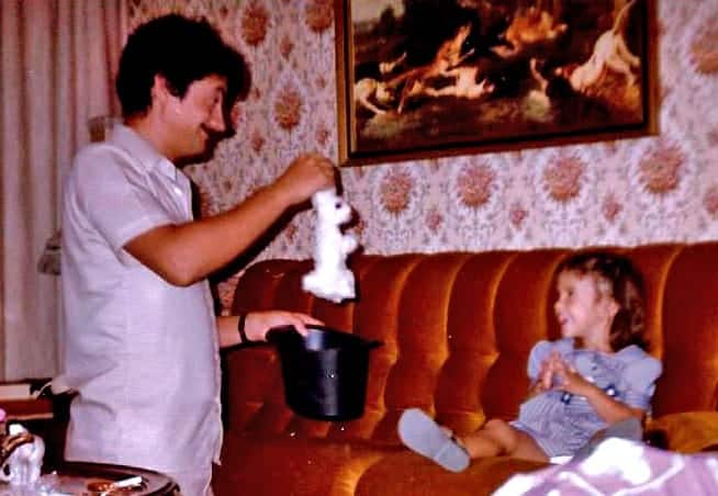 Little Susana Raya watching her dad perform her favorite trick: a rabbit coming out of a hat